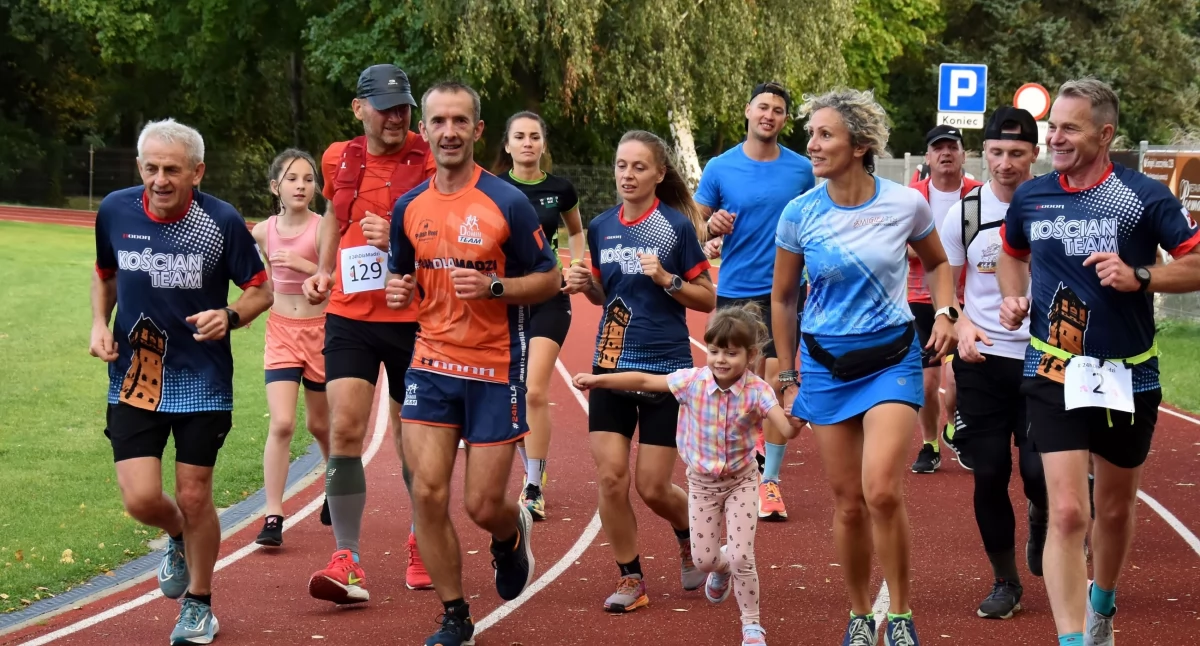 Zdjęcie przedstawia Dominika Wolffa i innych biegaczy podczas biegu 24-godzinnego
