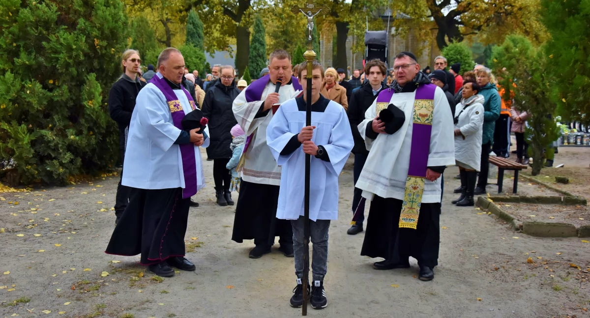 Zdjęcie przedstawia procesję żałobną podczas Wszystkich Świętych w Kościanie