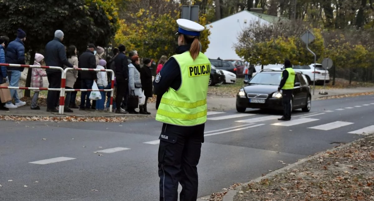 Zdjęcie przedstawia policjantkę czuwającą nad ruchem w okolicy cmentarza