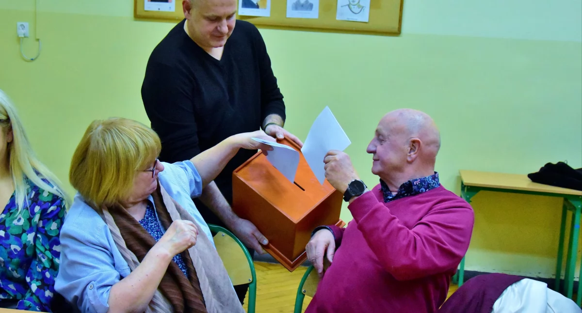 Zdjęcie przedstawia głosujących podczas zebrania mieszkańców jednego z osiedli w Kościanie