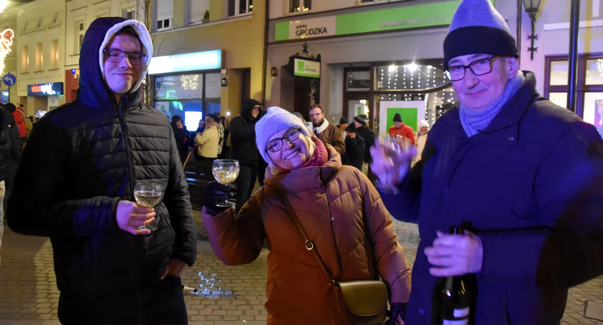 Zdjęcie przedstawia kościaniaków bawiących się w Nowy Rok na Rynku w Kościanie