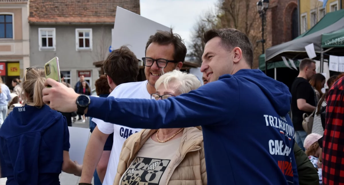 Minister Szłapka i europoseł Wawrykiewicz robiący sobie zdjęcie na Rynku w Kościanie